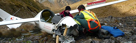 Two men beside crashed glider
