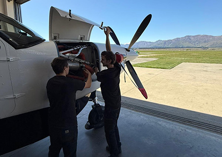 Engineers with small plane in hangar