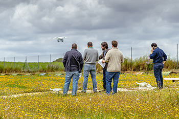 Five men in a field with a drone